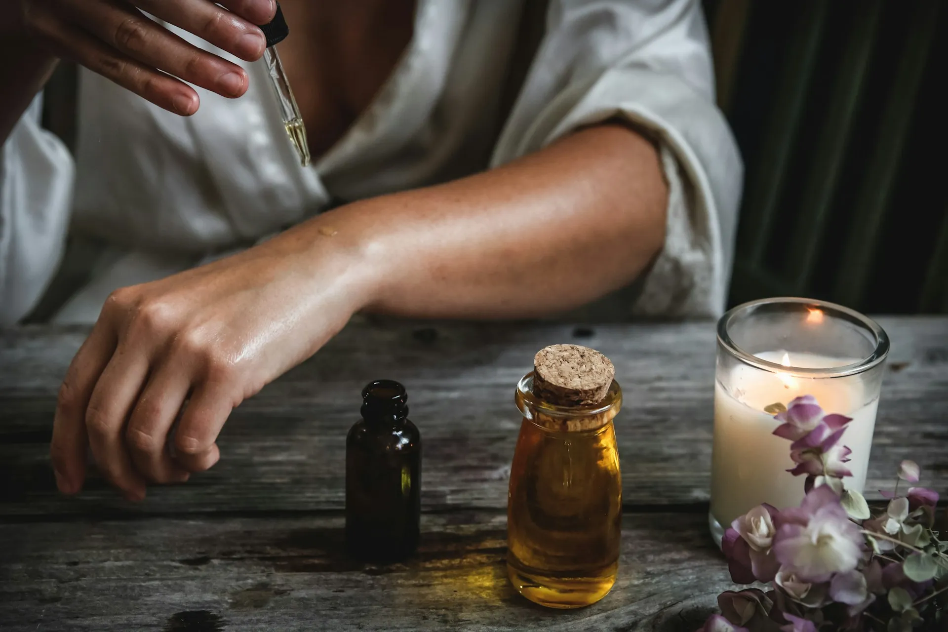 Essential oils and candles on a rustic wooden table